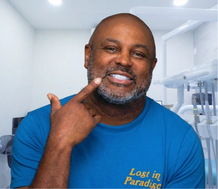 african american man with a full beard smiling gracefully, highlighting his new teeth