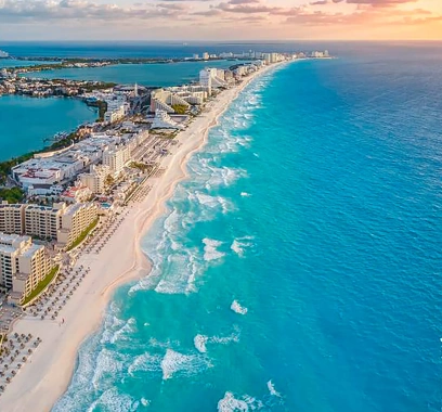 Breathtaking aerial view of the Cancun Hotel Zone at sunset, featuring turquoise Caribbean waters and luxury resorts