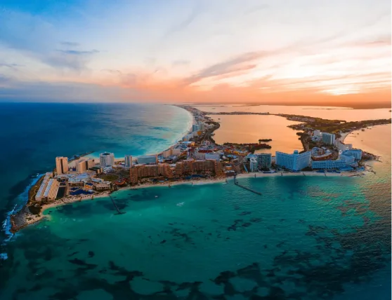 Aerial view of a beautiful coastal resort destination at sunset. Luxury hotels and beaches located between the ocean and a large lagoon.